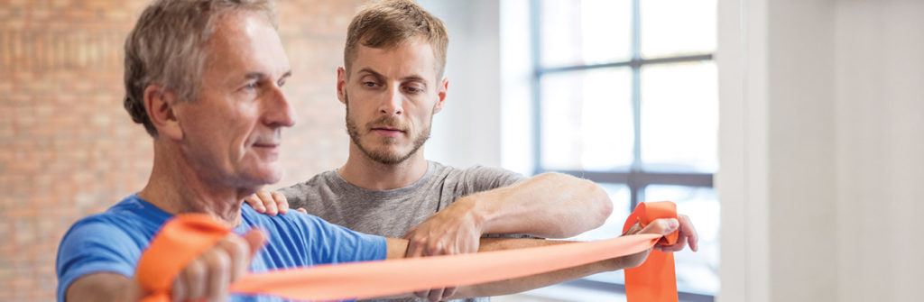 man with stretch band and trainer